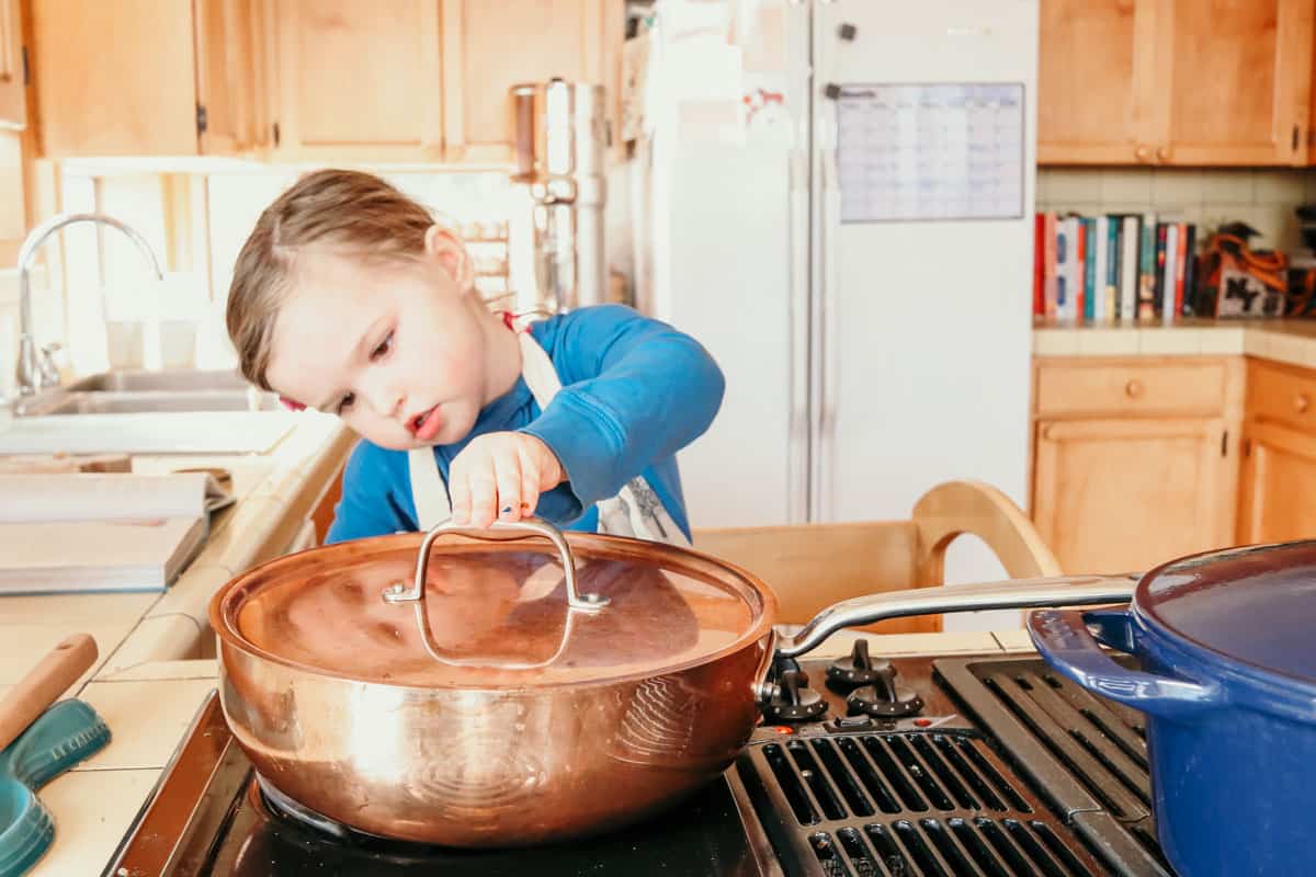 child placing the lid on a Made In Copper Saucier