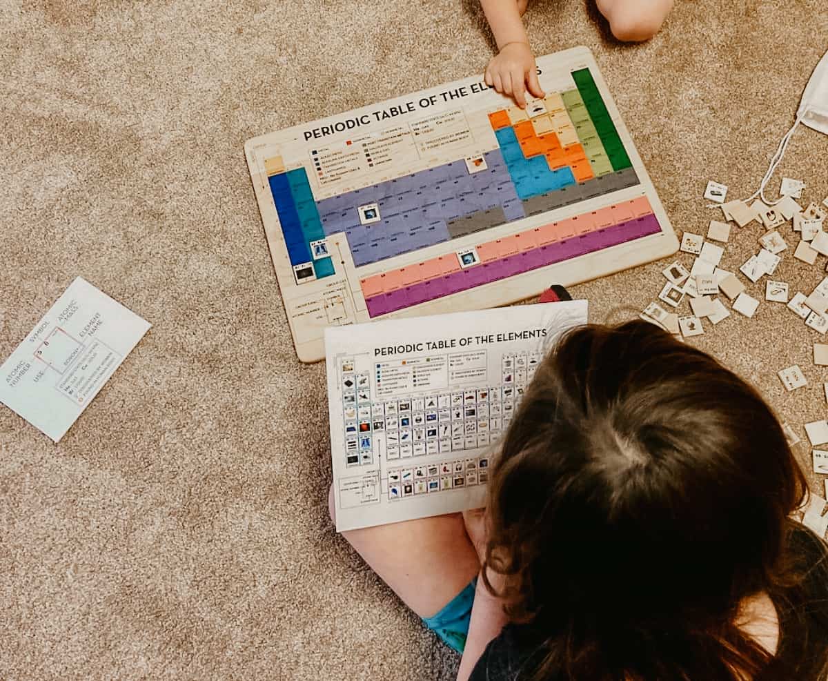 Montessori kids using Mirus Toys Periodic Table of Elements and key for exploring the history of the universe