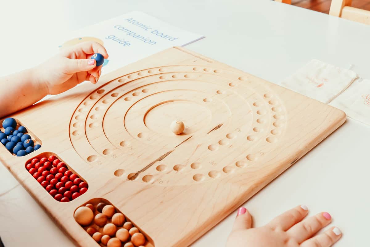 Closeup of the Mirus Toys Atomic Board with Companion Guide for exploring the history of the universe.