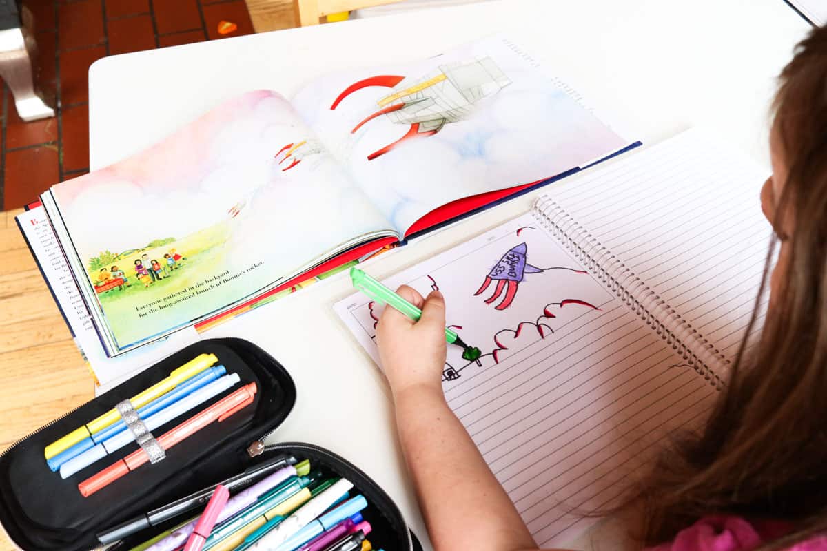 child using markers and an Erin Condren story notebook to draw a picture inspired by Bonnie's Rocket