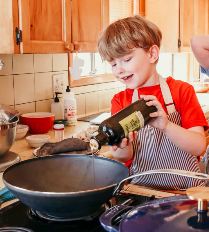 Noah is adding oil to a wok