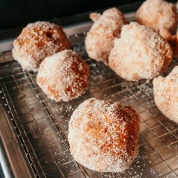deep-fried drop biscuits with cinnamon sugar on a rack