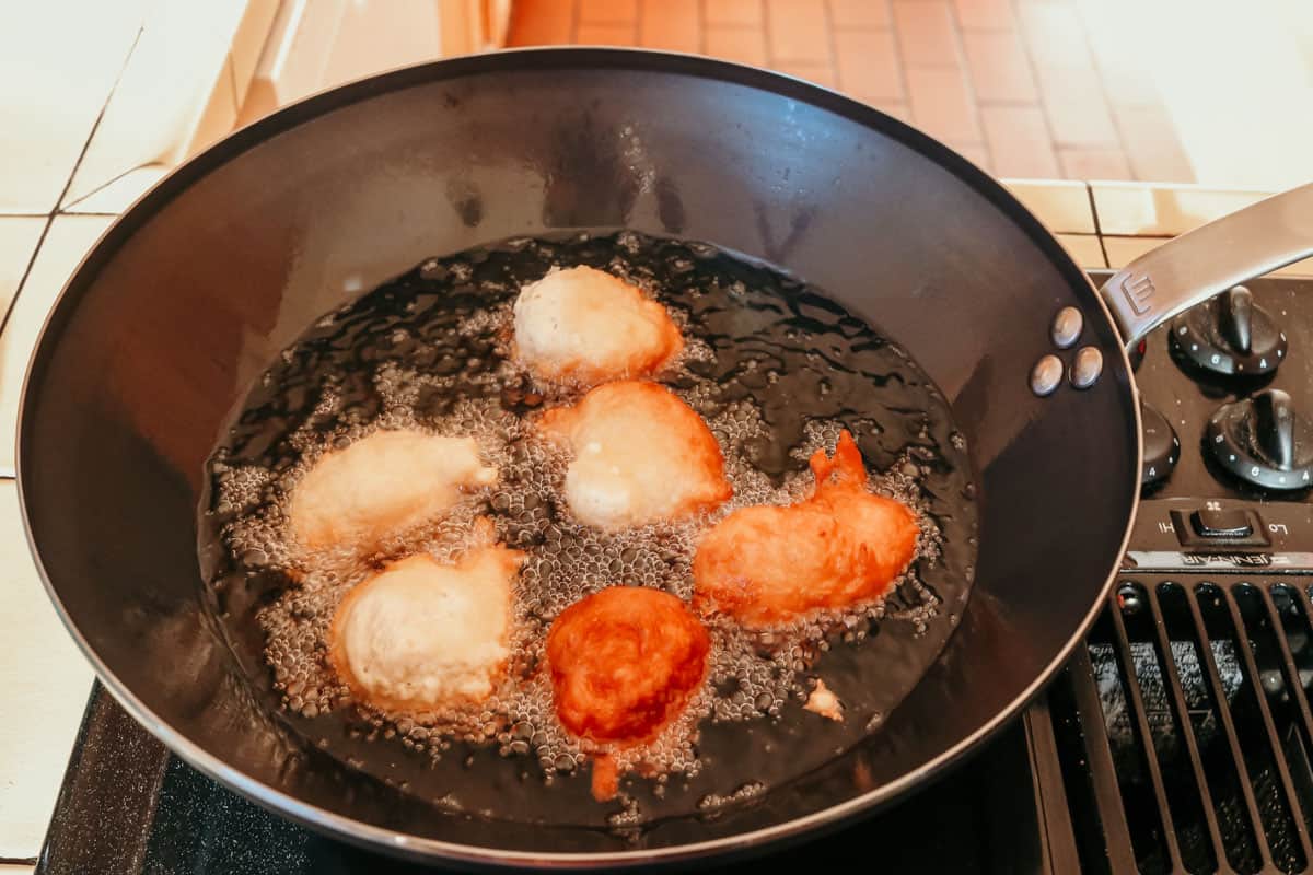 drop biscuits frying in a wok