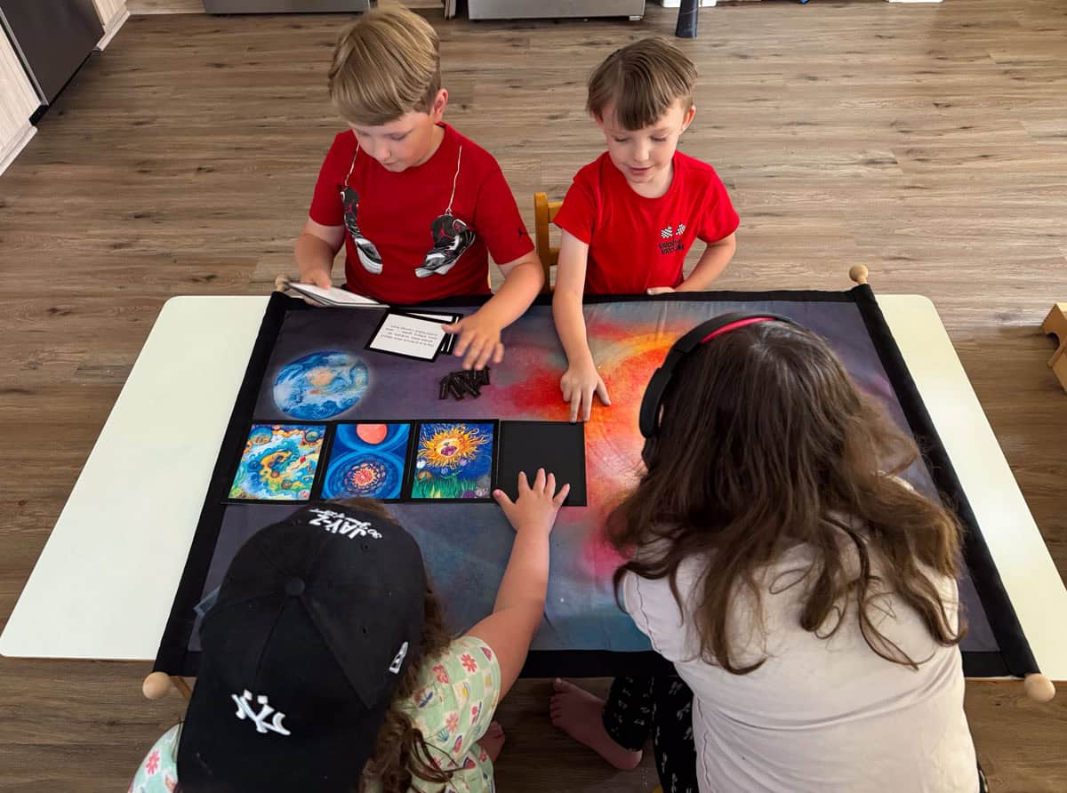 the kids are working with the Waseca Biomes Cosmic Story mat